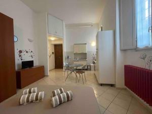 eine Küche und ein Wohnzimmer mit einem Tisch und einem Kühlschrank in der Unterkunft Minimal Loft in centro a Piacenza in Piacenza