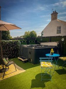 une pelouse avec une table, une chaise et un parasol dans l'établissement Wee Hoose-Private-Hottub -Romantic Break-Portaferry, 