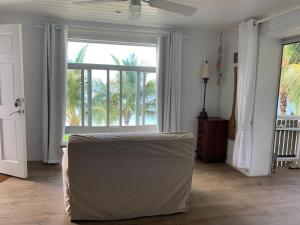 a living room with a couch and a large window at Beach'nBarefoot (Love Beach) - nestled on the beach in Orange Hill