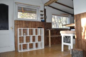 Zimmer mit einem weißen Bücherregal und einem Fenster in der Unterkunft Refugio El Cauque in Puerto Williams