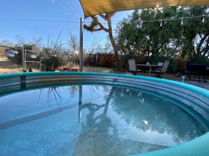 ジョシュア・ツリーにあるFloat Pool, Hot Tub, Sauna, Firepit, BBQ, Telescope, Views, EV Chg,の水中の人物を映したプール