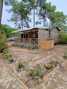 a small house with flowers in a yard at Mobil home 6 Personnes au Atlantic Club Montalivet in Vendays-Montalivet