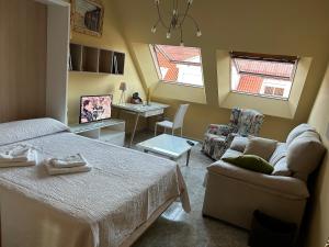比拉諾瓦德亞羅薩的住宿－Vista puerto deportivo，一间卧室配有一张床、一张沙发和一张书桌