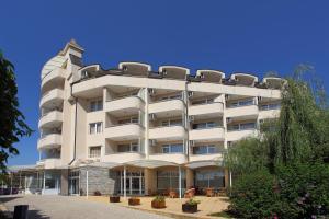 un grand bâtiment blanc avec des chaises en haut dans l'établissement Hotel Aurora, à Saints Constantine et Helena