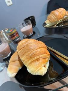 two croissants on a black plate on a table at Traum Wohnung mit Kingsize-Bett in Graz