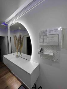 een kamer met een wit aanrecht met een spiegel bij Traum Wohnung mit Kingsize-Bett in Graz