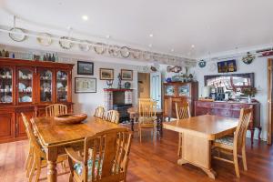 uma cozinha e sala de jantar com mesas e cadeiras de madeira em Anchors Aweigh - Adult & Guests Only em Narooma