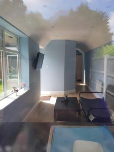 una sala de estar con una pared azul en Cosy Studio Luton en Luton