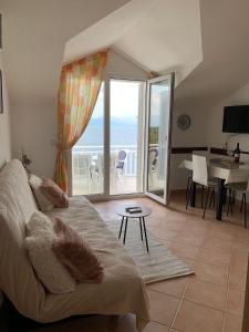 a living room with a couch and a view of the ocean at Apartmani ANCORA, Crkvice in Kuna Pelješka