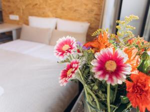 un jarrón de flores sentado en una mesa junto a una cama en Fregata, en Ustka