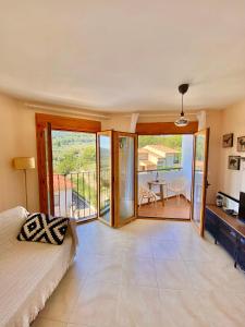 1 dormitorio con 1 cama y balcón con mesa en Las Vistas Apartment, en Guadalest