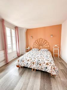 a bedroom with a large bed with a wooden headboard at Logement entier 75 m2 in Boulogne-Billancourt