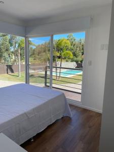 a bedroom with a bed and a large glass window at Casa para 4 personas en vista24uy, Bella Vista, Maldonado in Bella Vista