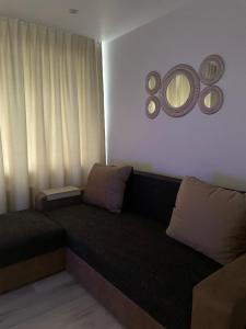 - un canapé dans une chambre avec un miroir mural dans l'établissement KOLIBRI, à Ludza