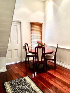 d'une salle à manger avec une table, des chaises et une fenêtre. dans l'établissement Charming Federation style home minutes from CBD, à Perth
