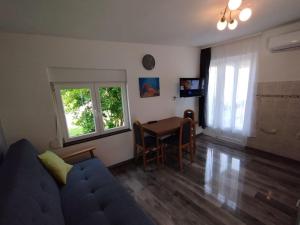 a living room with a blue couch and a table at Apartman Marija in Zlarin