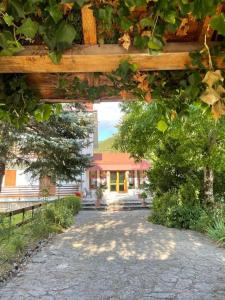 un chemin menant à une maison avec une arche en bois dans l'établissement Casa Peppone, à Pescasseroli