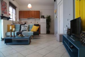 Il comprend un salon avec un canapé bleu et une cuisine. dans l'établissement Lux δυάρι με parking στο κέντρο, à Vólos