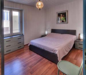 a bedroom with a bed and two chairs and a window at Vista sulla marina, AC, ascensore in Savona