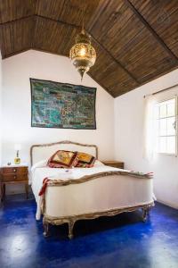 a bedroom with a bed and a chandelier at Cozy Country House in Colonia - Uruguay in Real de San Carlos