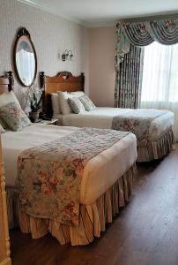 a hotel room with two beds and a mirror at Boardwalk Plaza Hotel in Rehoboth Beach