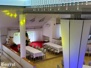 um quarto com mesas e cadeiras num quarto com luzes em Boierul la Florenta em Dej