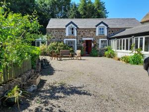 una casa de piedra con un patio frente a ella en Moira Cottages at Berwickhall Sleeps 8, en Moira