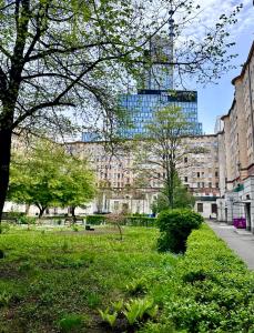 een park met een hoog gebouw op de achtergrond bij Nice Stay Apartment Centrum in Warschau