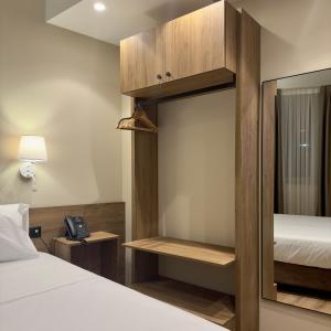 a hotel room with a bed and a mirror at Aragosta Hotel & Restaurant in Durrës