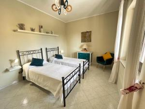 マッサ・ルブレンセにあるCasa Gabyのベッドルーム1室(ベッド2台、青い椅子付)