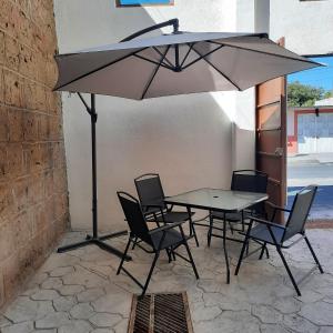 - une table et des chaises sous un parasol sur la terrasse dans l'établissement Hotel Tlaxcala, à Tlaxcala de Xicohténcatl