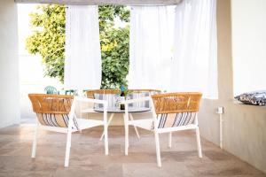 a dining room with a white table and chairs at The Windmill Villa in Lampi