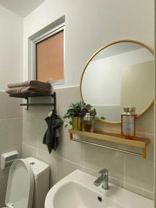 e bagno con specchio, servizi igienici e lavandino. di Alanis Residence Master Bedroom a Sepang