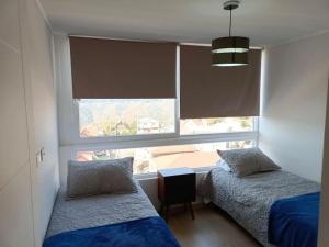 ビーニャデルマールにあるDepartamento 2D y 2B Viña del marのベッドルーム1室(ベッド2台、大きな窓付)