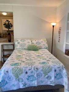 a bed with a blue and white comforter in a room at Seashell Studio near FIT/beach in Melbourne