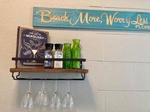 a shelf with bottles and a sign on a wall at Seashell Studio near FIT/beach in Melbourne