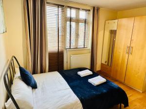 um quarto com uma cama com duas toalhas em London Mackenzie Apartment em Londres