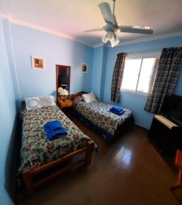 聖米格爾德圖庫曼的住宿－La Rojarilla，一间卧室配有两张床和吊扇