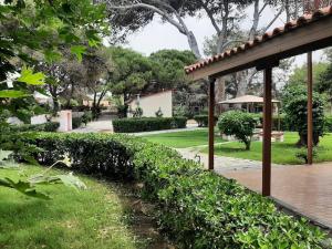 a hedge in front of a garden with a pavilion at Yannis Villa in Katarrákhion
