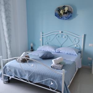 - une chambre bleue dotée d'un lit avec un mur bleu dans l'établissement Junno Maison Doli', à Mattinata