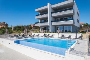 a villa with a swimming pool in front of a building at Villa Lavanda in Novalja