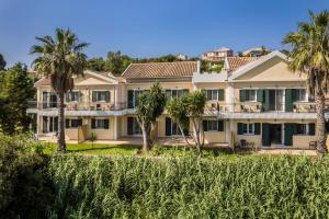 an exterior view of a large house with palm trees at Theros Retreat in Spartia