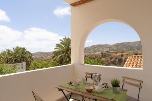 Cette chambre comprend une table et une fenêtre d'arche. dans l'établissement Finca Artiles, à Las Palmas de Gran Canaria