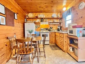 cocina con paredes de madera, mesa y sillas en Stargazers Cove Cottages Blue Heron, en Middleton