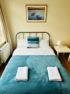 a bed with two towels sitting on top of it at London Mackenzie Apartment in London