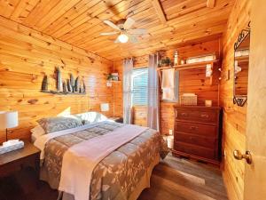 a bedroom with a bed in a log cabin at Stargazers Cove Cottages Blue Heron in Middleton