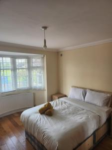 a teddy bear laying on a bed in a bedroom at Cosy 3 Bedroom Home in Notts in Nottingham