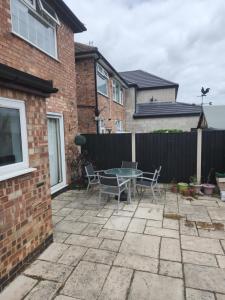 a patio with a table and chairs in front of a house at Cosy 3 Bedroom Home in Notts in Nottingham