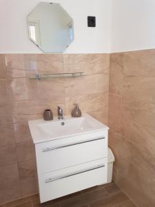 ザラカロシュにあるHenrietta Apartmanházのバスルーム(白い洗面台、鏡付)
