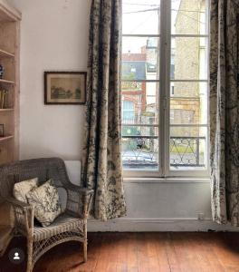 a living room with a chair and a window at Le Grand apartment dan Dieppe - Charming home 2-8 guests in Dieppe